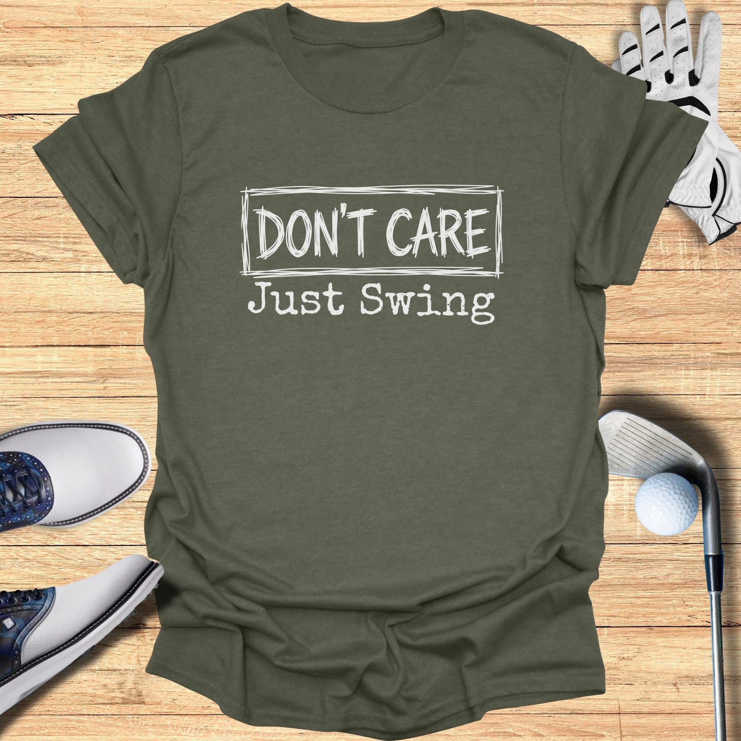 Olive green t-shirt with "DON'T CARE Just Swing" text, golf club, glove, and shoes.