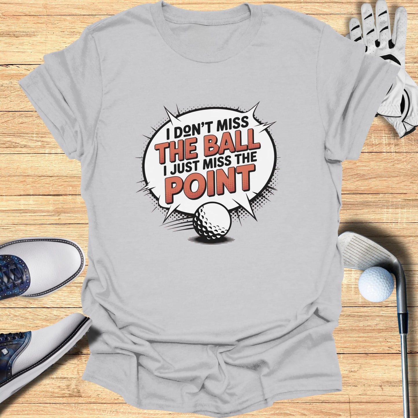 Gray t-shirt with "I don't miss the ball I just miss the point" golf graphic.