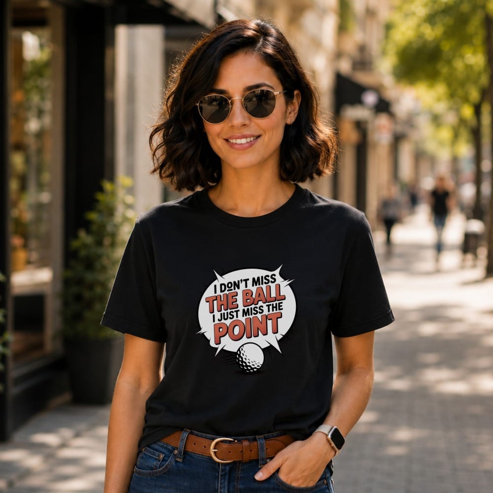 Black t-shirt with text "I don't miss the ball, I just miss the point" and golf ball.