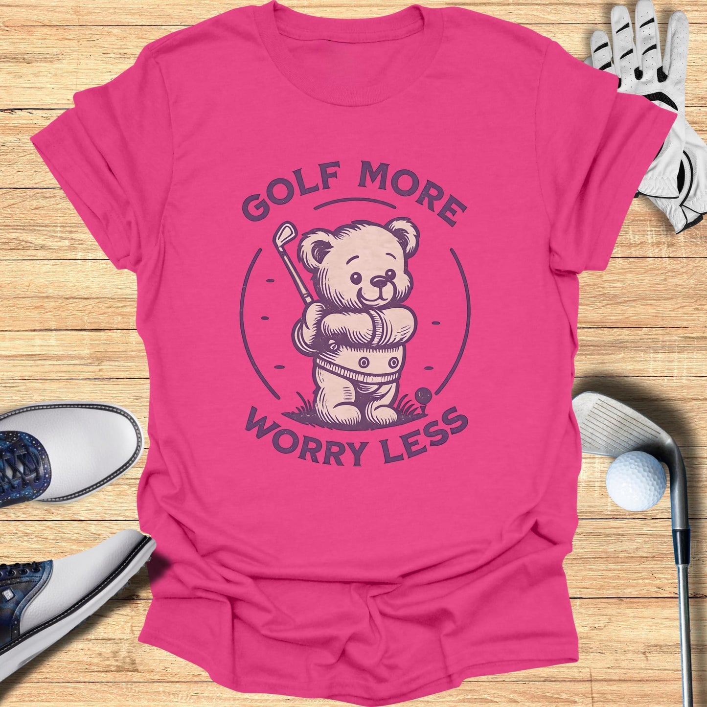 Pink t-shirt with a cartoon bear golfing and the text "Golf More Worry Less."