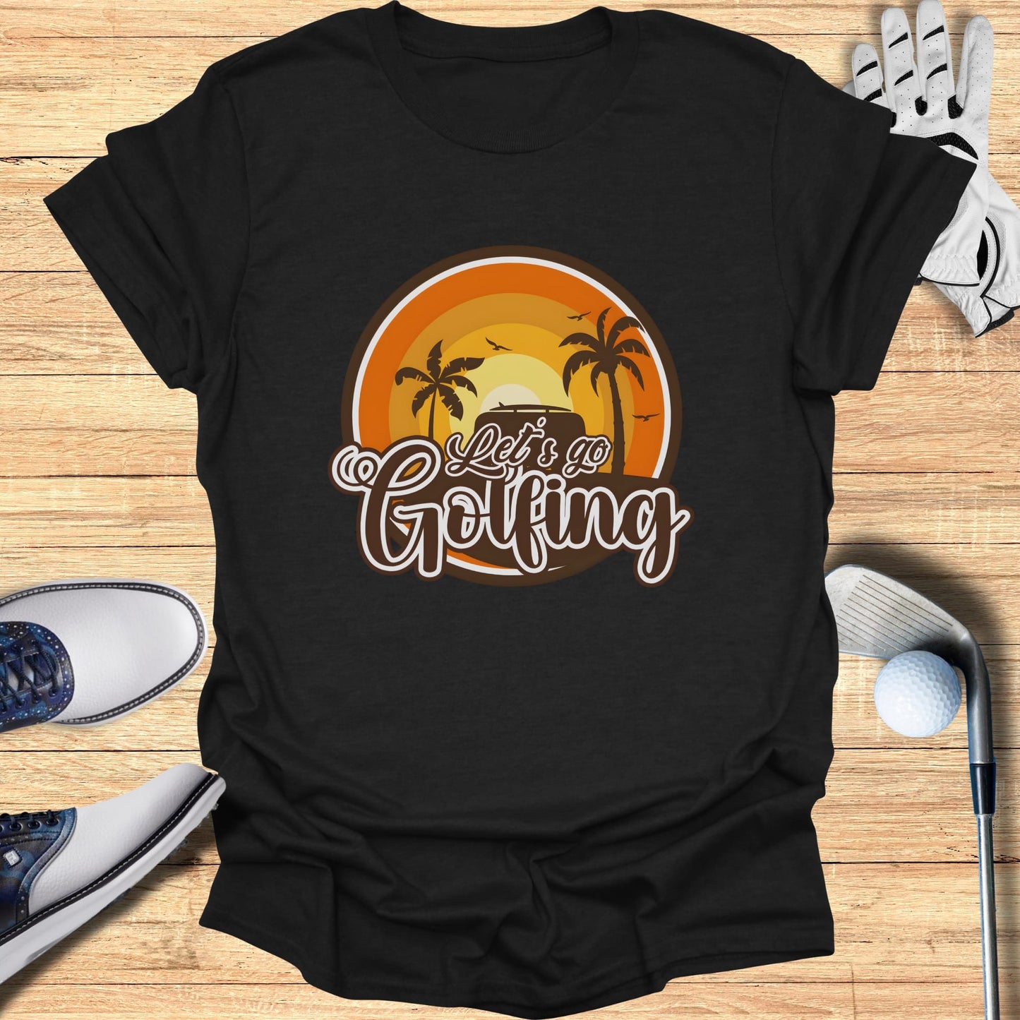 Black t-shirt with "Let's Go Golfing" text and sunset palm trees graphic.