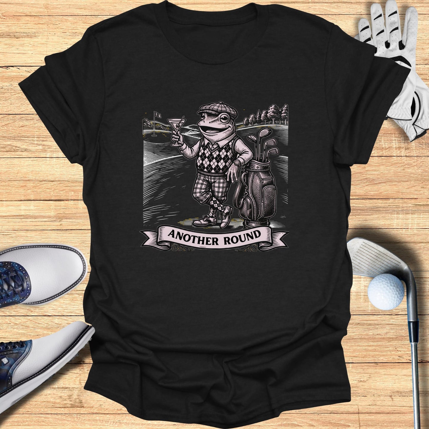 T-shirt featuring a frog golfer with a drink and golf bag, text "Another Round".
