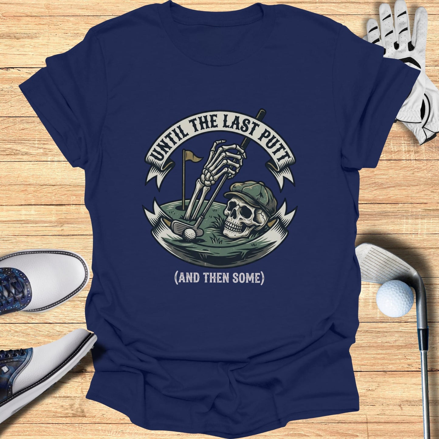 Dark blue t-shirt with a skeleton golfing graphic and "Until the Last Putt (and then some)" text.