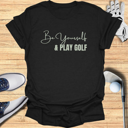 Black t-shirt with "Be Yourself & Play Golf" text in script font.