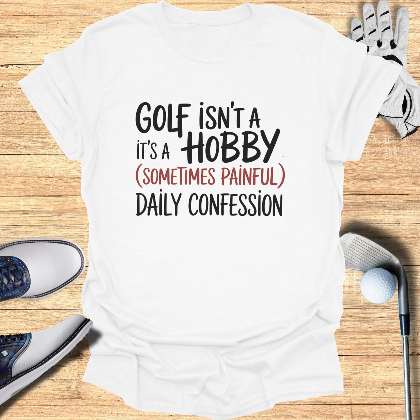 White t-shirt with "Golf isn't a hobby, it's a (sometimes painful) daily confession."