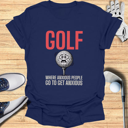 Navy t-shirt with "GOLF WHERE ANXIOUS PEOPLE GO TO GET ANXIOUS" text and worried golf ball graphic.
