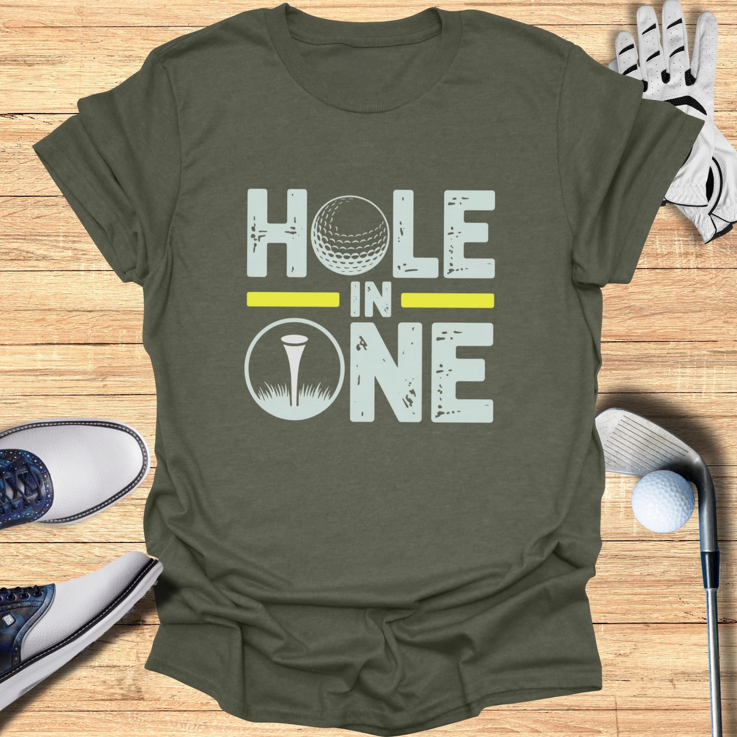 Green t-shirt with "HOLE IN ONE" text and a golf ball and tee graphic.