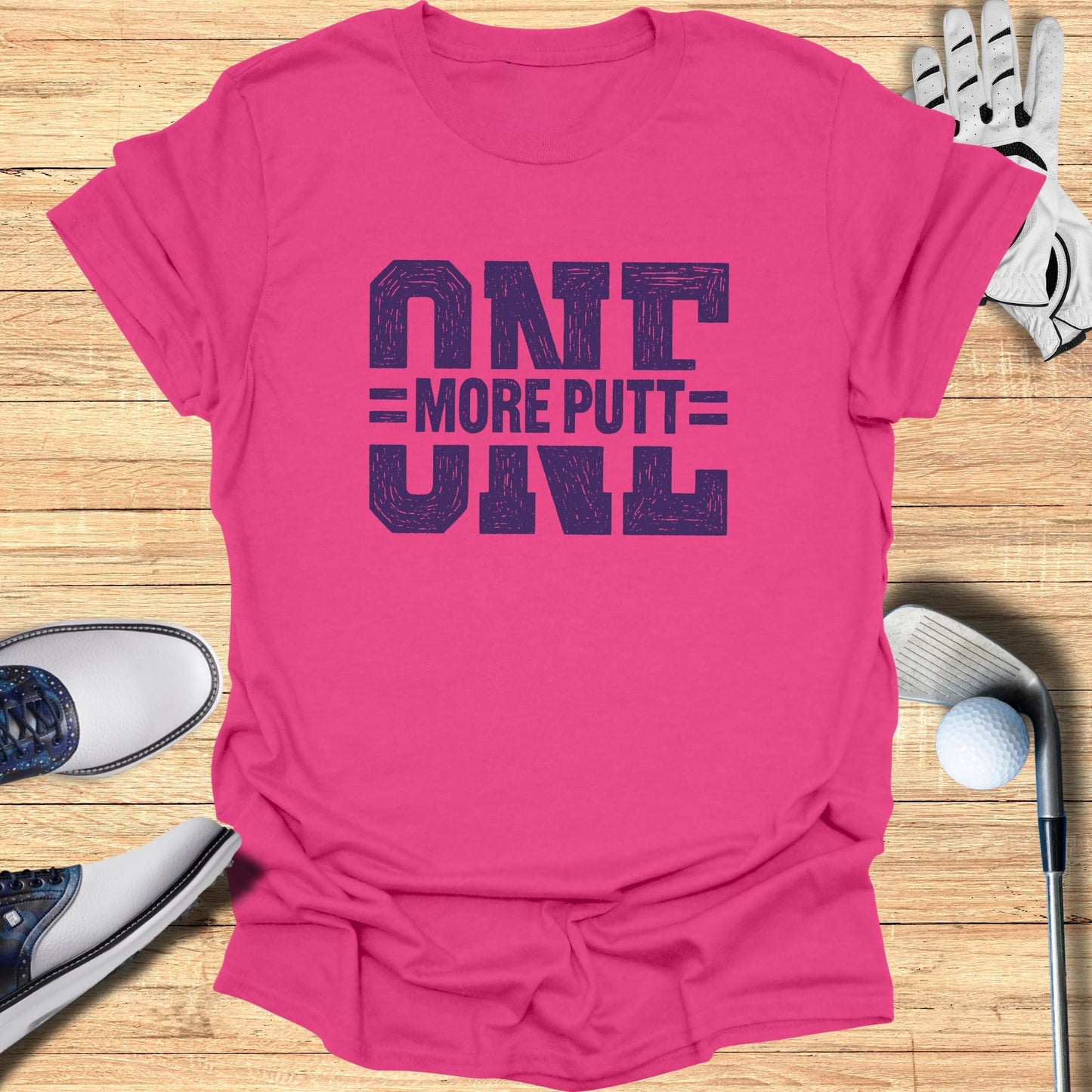 Pink t-shirt with "ONE MORE PUTT" text in bold, block letters.