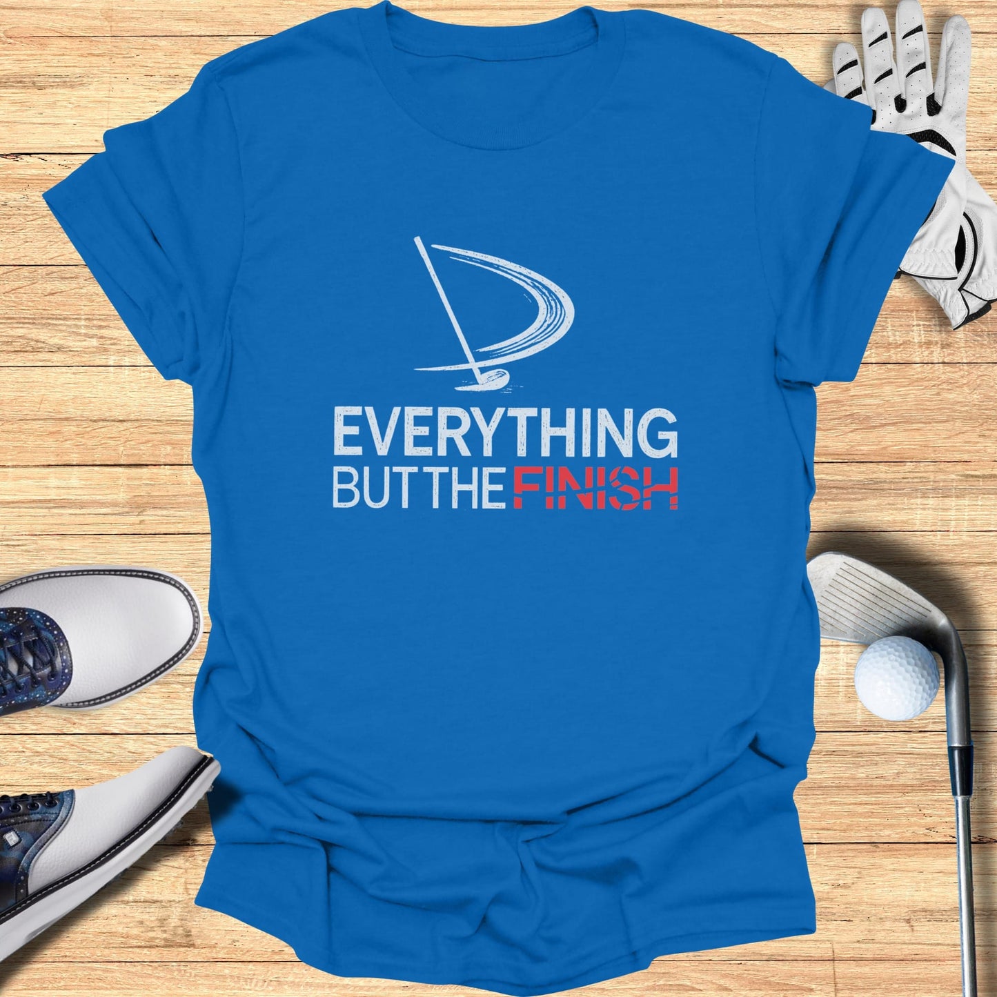 Blue t-shirt with white and red "EVERYTHING BUT THE FINISH" text and golf graphic.