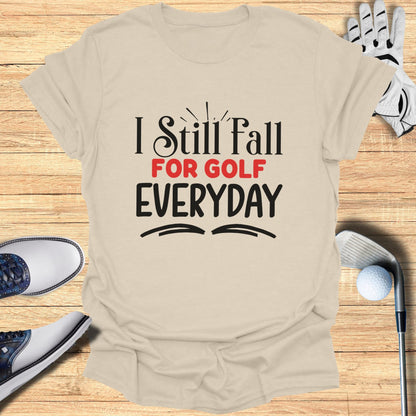 T-shirt with "I Still Fall FOR GOLF EVERYDAY" text and golf accessories.