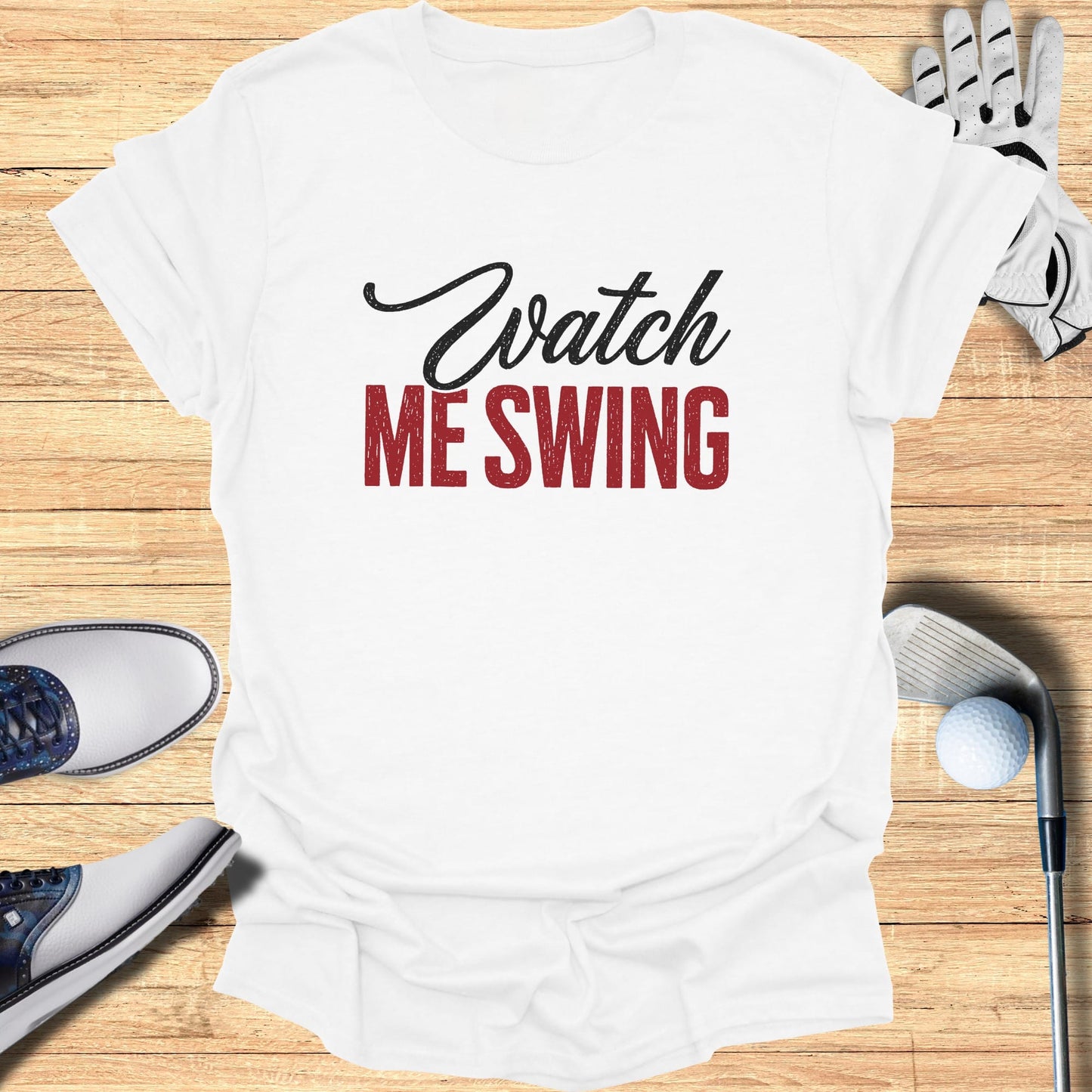 White t-shirt with "Watch ME SWING" text and golf accessories.
