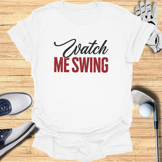 White t-shirt with "Watch ME SWING" text and golf accessories.
