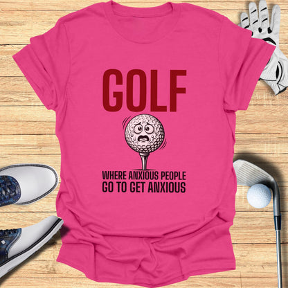 Pink t-shirt with "GOLF WHERE ANXIOUS PEOPLE GO TO GET ANXIOUS" and golf ball graphic.