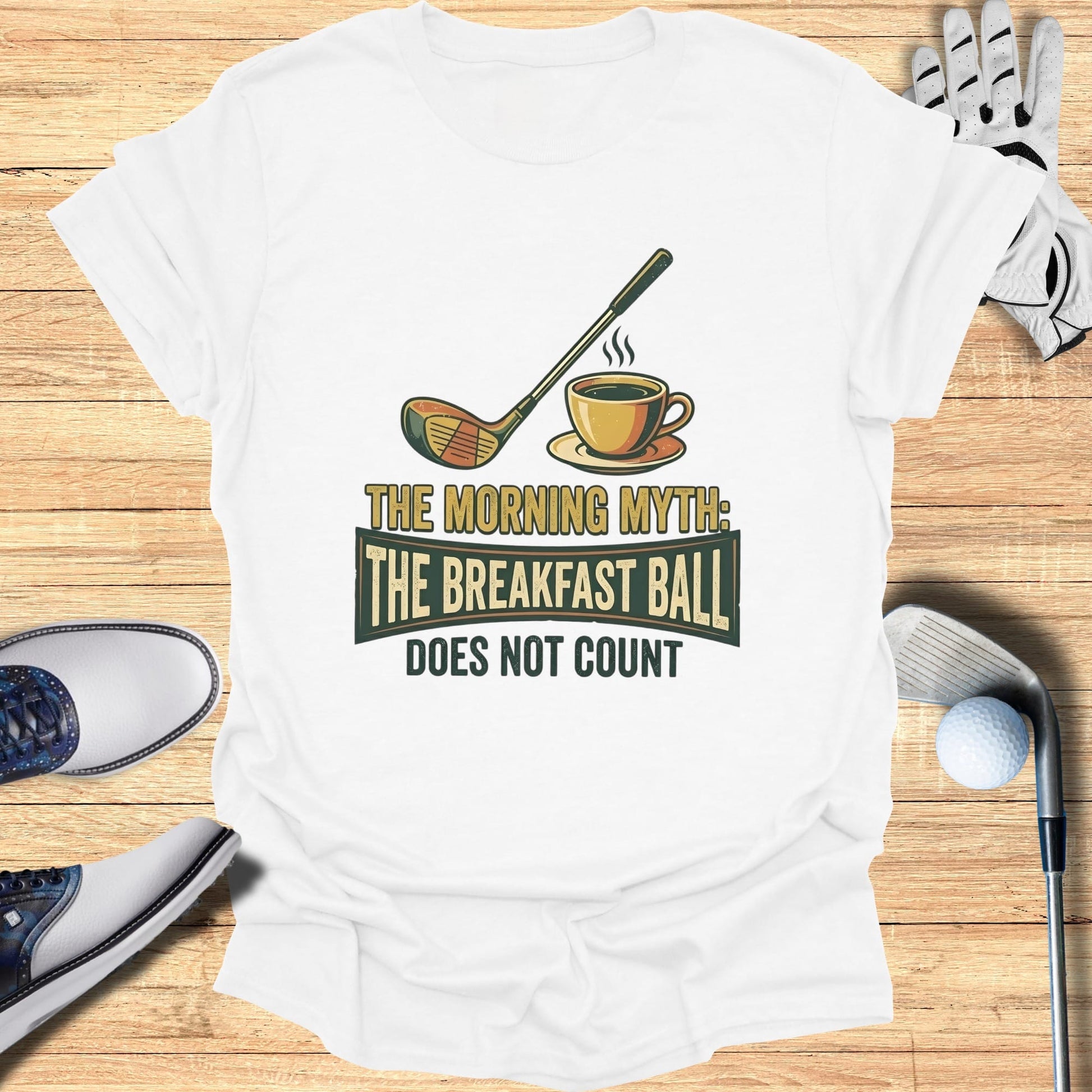 White t-shirt with "The Morning Myth: The Breakfast Ball Does Not Count" text and golf graphics.