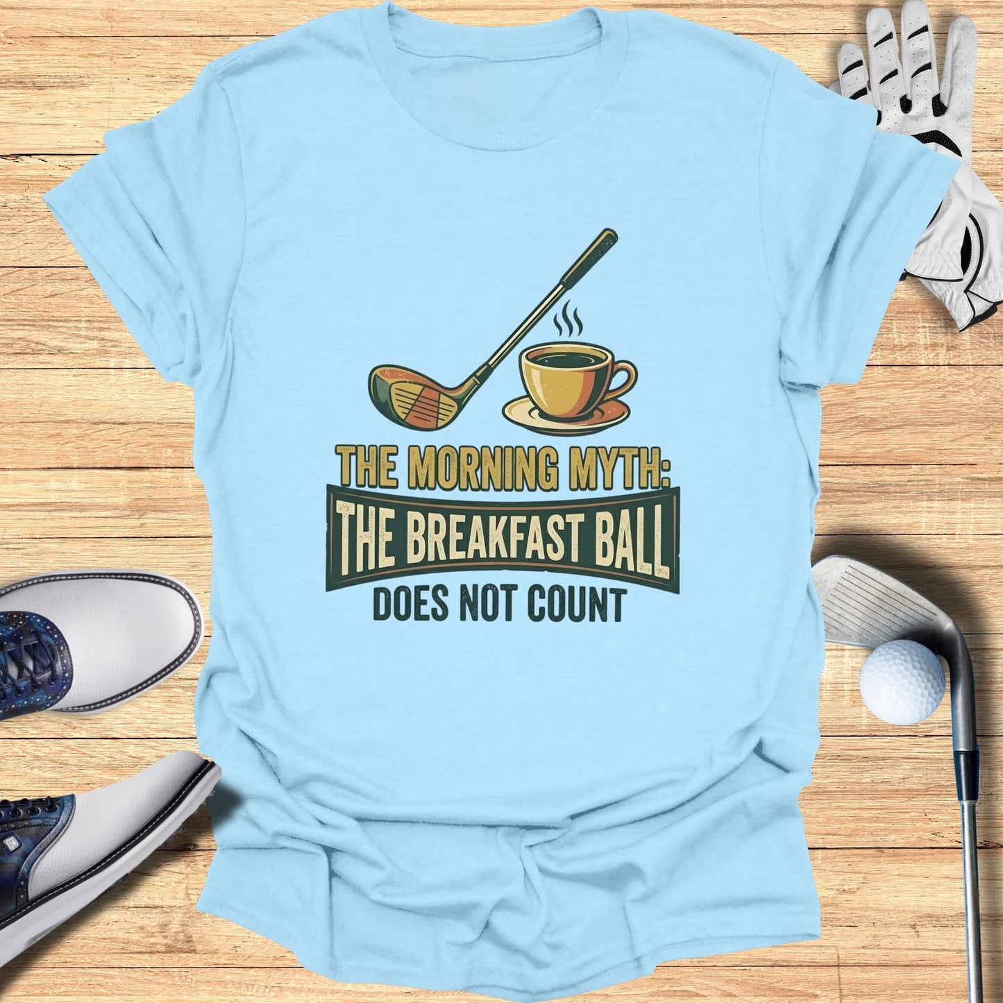 T-shirt with golf club, coffee cup, and text "The Morning Myth: The Breakfast Ball Does Not Count".